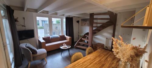un salon avec une table en bois et un escalier en colimaçon dans l'établissement Vakantiewoning Zonnige Blik, à Domburg