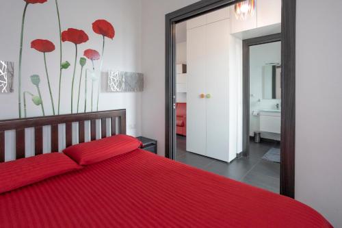 um quarto com uma cama vermelha e um espelho em HomeHouse Candia - Vatican Attic em Roma