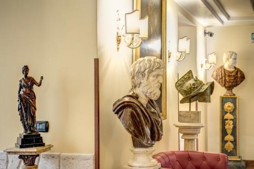 羅馬的住宿－奧勒留藝術畫廊酒店，女雕像和其他雕像在房间里被灌木丛所破坏