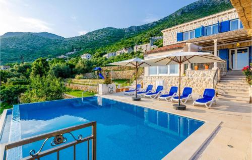 a villa with a swimming pool with mountains in the background at Stunning Home In Brsecine With Outdoor Swimming Pool in Brsečine