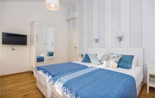 a bedroom with a large bed with blue pillows at Stunning Home In Brsecine With Outdoor Swimming Pool in Brsečine