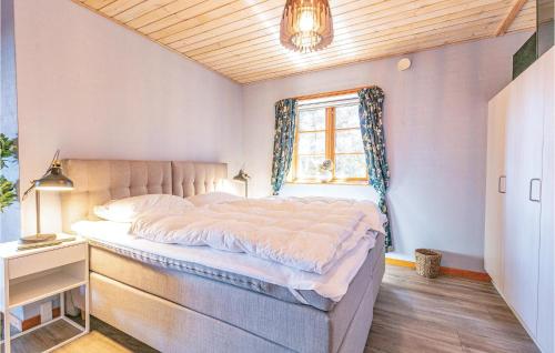 a bedroom with a large bed with a window at Alpehuset in Allinge