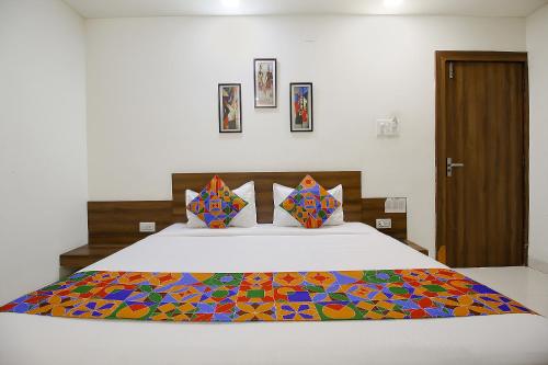 Un dormitorio con una cama con una manta de colores. en FabExpress Comfort Stay I en Bhopal