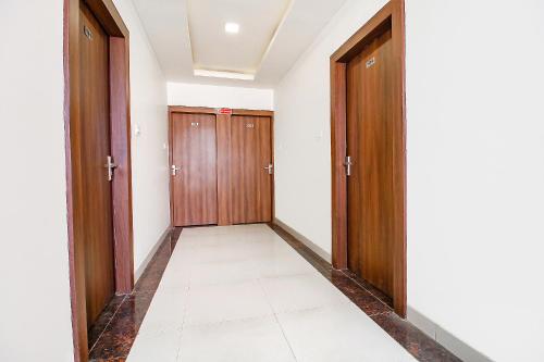 a hallway with two wooden doors and a tile floor at FabExpress Comfort Stay I in Bhopal