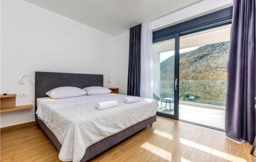 a bedroom with a bed and a large window at Nice Home In Zrnovnica With Heated Swimming Pool in Žrnovnica