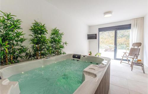 a large bath tub in a room with plants at Nice Home In Zrnovnica With Heated Swimming Pool in Žrnovnica
