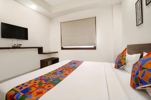 a bedroom with a bed and a television in it at FabExpress Comfort Stay I in Bhopal