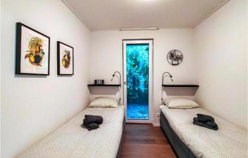 Duas camas num quarto com uma janela em Vakantiehuis 56 em Oosterwolde