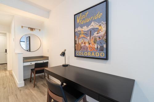 Zimmer mit einem Schreibtisch und einem Wandgemälde in der Unterkunft Bear Creek Lodge 207B by Alpine Lodging Telluride in Telluride