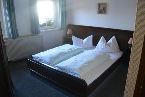 1 dormitorio con 2 camas y almohadas blancas en Naumann`s Hotel & Restaurant, en Burgstaedt