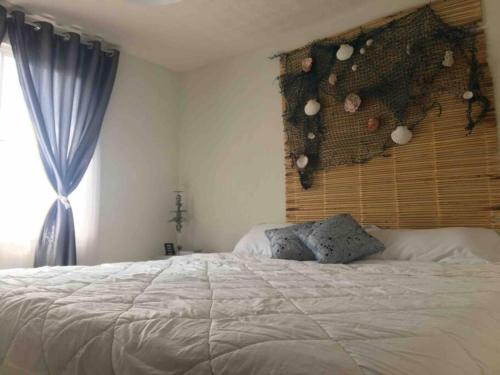 Un dormitorio con una gran cama blanca y una ventana en Casa en comarca minera en Acayuca