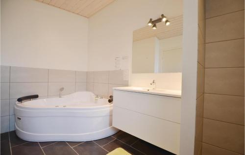 Baño blanco con bañera y lavamanos en Gorgeous Home In Ebeltoft With Wifi, en Ebeltoft