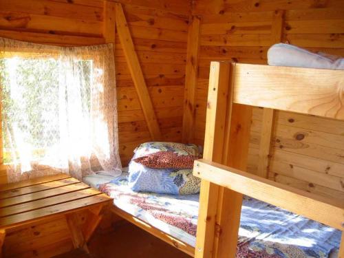 a bedroom with two bunk beds in a log cabin at Kõljala puhkeküla in Kaali