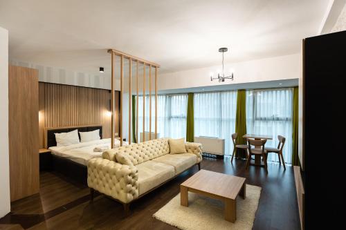 a bedroom with a bed and a couch and a table at The ONE Apart Hotel Luxury Suites & Apartments in Skopje