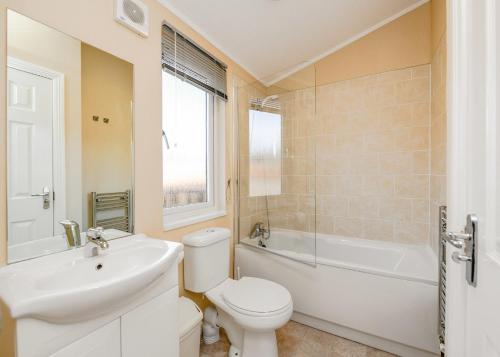 a bathroom with a toilet and a sink and a bath tub at South Lakeland Leisure Village in Hornby