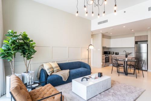 a living room with a blue couch and a table at Elegant Luxury Apartment with Stunning Lake Views in Dubai Creek Harbour By ĀYA Boutique in Dubai