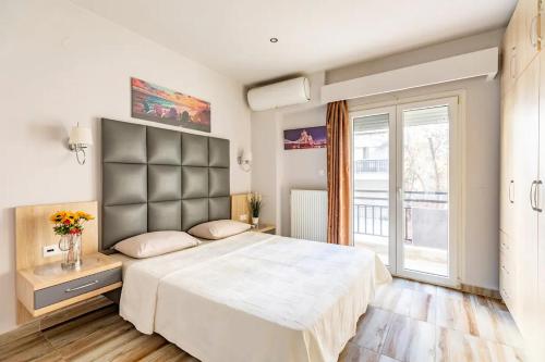 a bedroom with a large bed and a large window at Denis Apartment in Thessaloniki