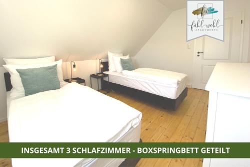 two beds in a small room with at Ferienhaus Fantaisie - Wohnen nahe Schlosspark -Stadtgrenze Bayreuth für 1-5 Pers, Hunde willkommen, voll eingezäunt in Eckersdorf