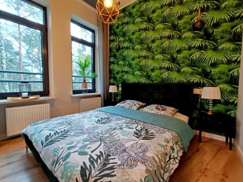 a bedroom with a green wall with a bed at Apartament nad Zalewem in Serock