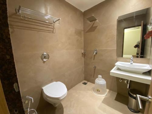 a bathroom with a toilet and a sink at Hotel Plaza Heights by RAK Rooms, Mangaluru in Mangalore