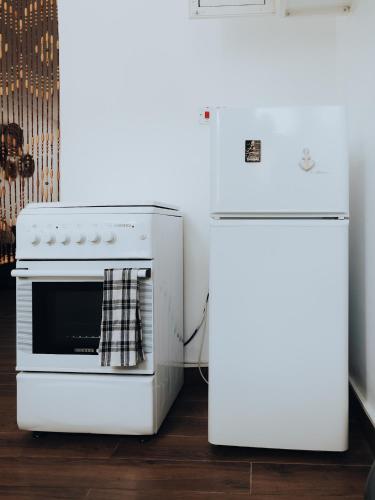 a white oven and a refrigerator in a kitchen at BT Seaside Cottages in Mkunguni