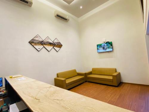 uma sala de estar com duas cadeiras e um sofá em Hotel Plaza Heights em Mangalore