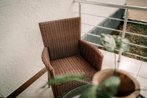a wicker chair sitting on a balcony with a plant at BT Seaside Cottages in Mkunguni