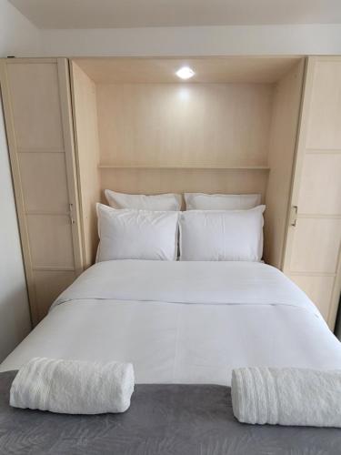 a large white bed with two pillows on it at Studio 1 à La Trinité proche de Nice, Monaco et l'Italie in La Trinité