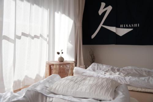 a bedroom with two unmade beds and a window at 久HISASHI 今池 Nagoya in Nagoya