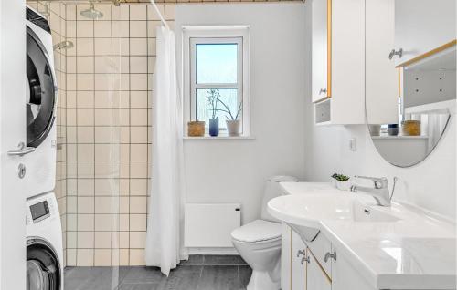 een witte badkamer met een toilet en een wastafel bij Nice Home In Fars With Kitchen in Farsø