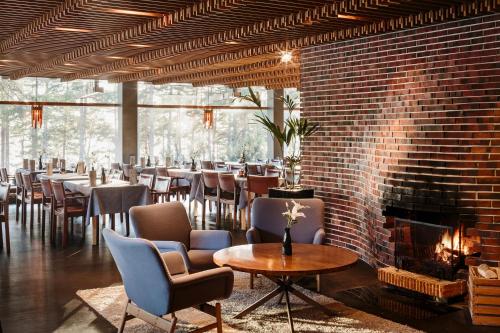 un restaurante con chimenea, mesas y sillas en Hotel Rantapuisto, en Helsinki