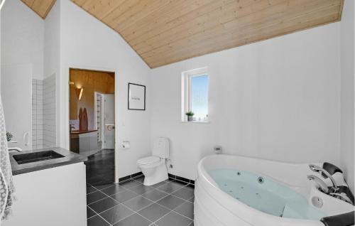 トランにあるAmazing Home In Lgstr With 4 Bedrooms, Sauna And Wifiの白いバスルーム(バスタブ、トイレ付)