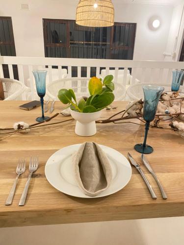 una mesa con un plato con una servilleta. en Imasiku House, en Southbroom