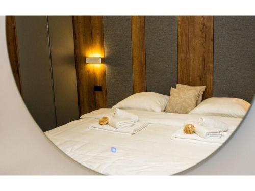 riflesso a specchio di un letto con asciugamani di Swiss Plus Hotel a Bihać