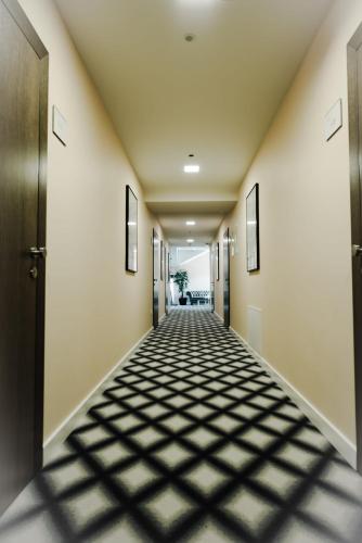 an empty hallway with a tile floor in a building at Swiss Plus Hotel in Bihać