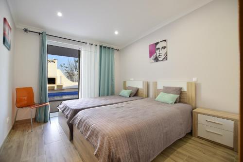 een slaapkamer met een bed en een groot raam bij Villa Prestige Five Sea View Marina By TatiHomes in Albufeira