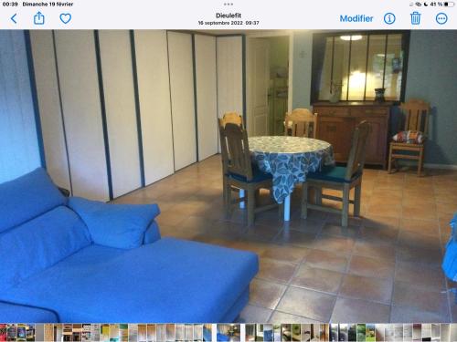 un salon avec un canapé, une table et des chaises dans l'établissement La fabrique des petits bonheurs, à Dieulefit