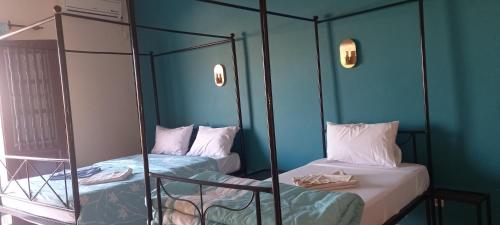 サン・ルイにあるHÔTEL ETOILE DU SUDの青い壁の客室で、二段ベッド2台が備わります。