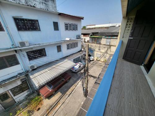 a view from a balcony of a building with a car at Achcha hotel - itsaraphap MRT station - Wat Arun in Bangkok