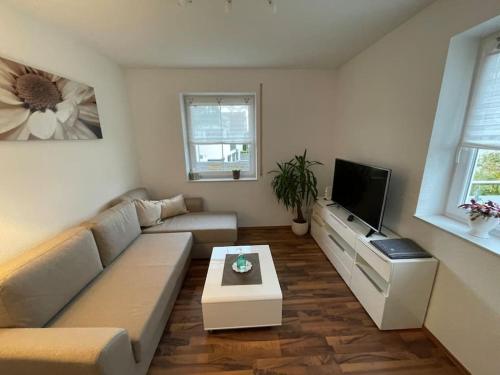 a living room with a couch and a flat screen tv at Melli‘s Seenahe Ferienwohnung in Langenargen