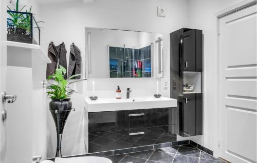 uma casa de banho branca com um lavatório e um espelho em Cozy Home In Jgerspris With Wifi em Jægerspris