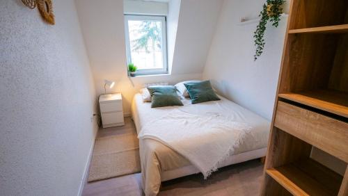 een kleine slaapkamer met een bed en een raam bij # Le 4 # Très beau appartement T3 Neuf, tout confort, Mulhouse centre ville in Mulhouse