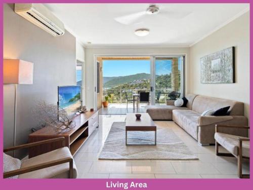 a living room with a couch and a tv at 52 Airlie Beach Beauty at The Summit in Airlie Beach