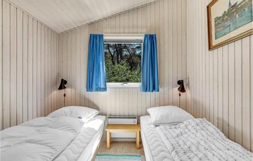 Vester SømarkenにあるGorgeous Home In Nex With Wifiのベッドルーム1室(ベッド2台、青いカーテン付きの窓付)