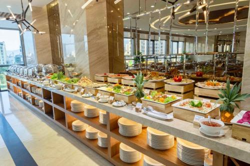 une ligne de buffet avec des assiettes et des aliments exposés dans l'établissement Pavilion Hotel Da Nang, à Đà Nẵng