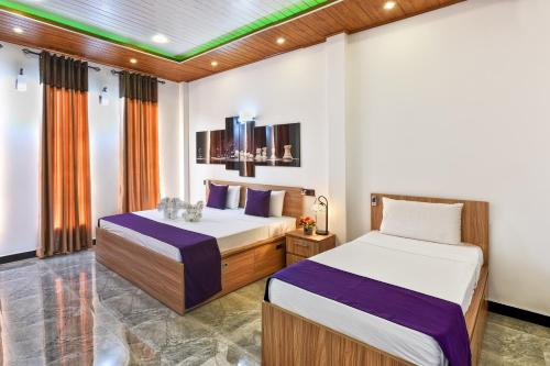 a bedroom with two beds in a room at White Land City Hotel in Dambulla
