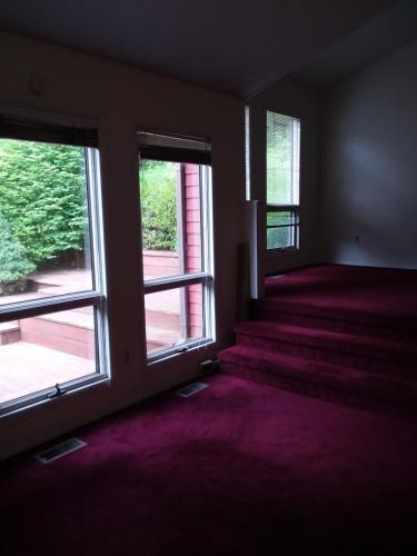 um quarto vazio com duas janelas e alcatifa roxa em Master Bedroom with Garden View em Huntington