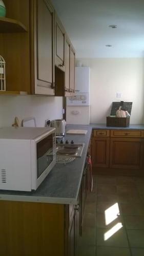 a kitchen with a white microwave on a counter at Large countryside home in Tow Law