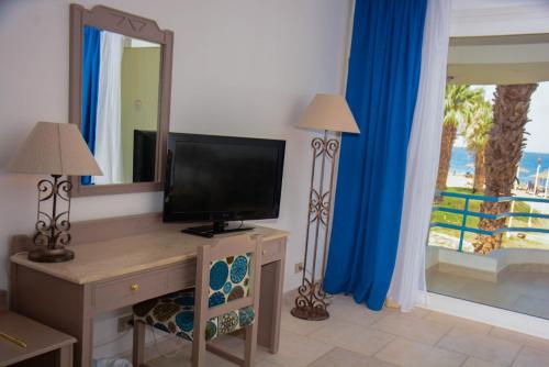 a living room with a television and a mirror at Queen Sharm Italian Club in Sharm El Sheikh