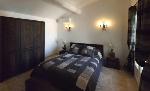 sypialnia z łóżkiem z niebieską i szarą kołdrą w obiekcie Mas Dansavan Chambres d'hôtes w mieście Oppède